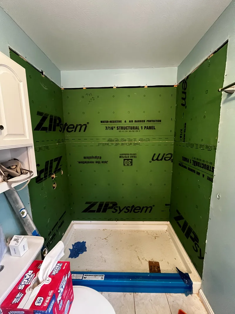 All three shower walls closed in moisture-resistant plywood backing before the acrylic goes on