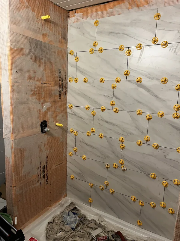 Tile being installed over waterproofing membrane
