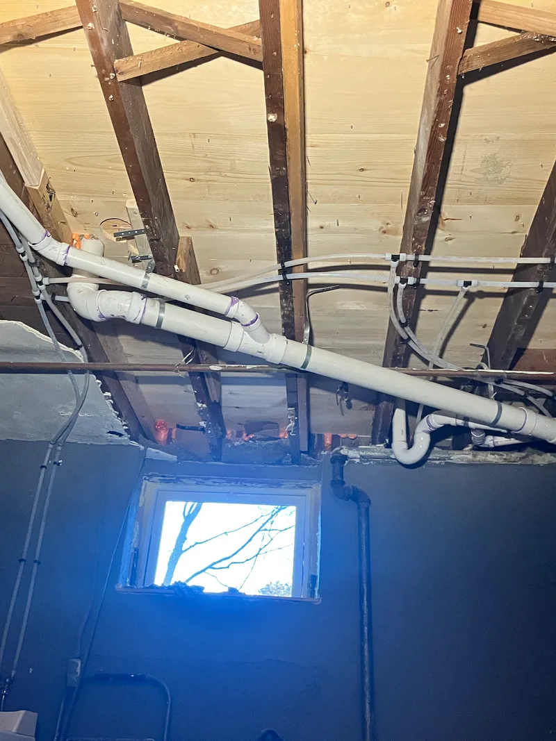 New drain and water supply lines run in the basement below the bathroom