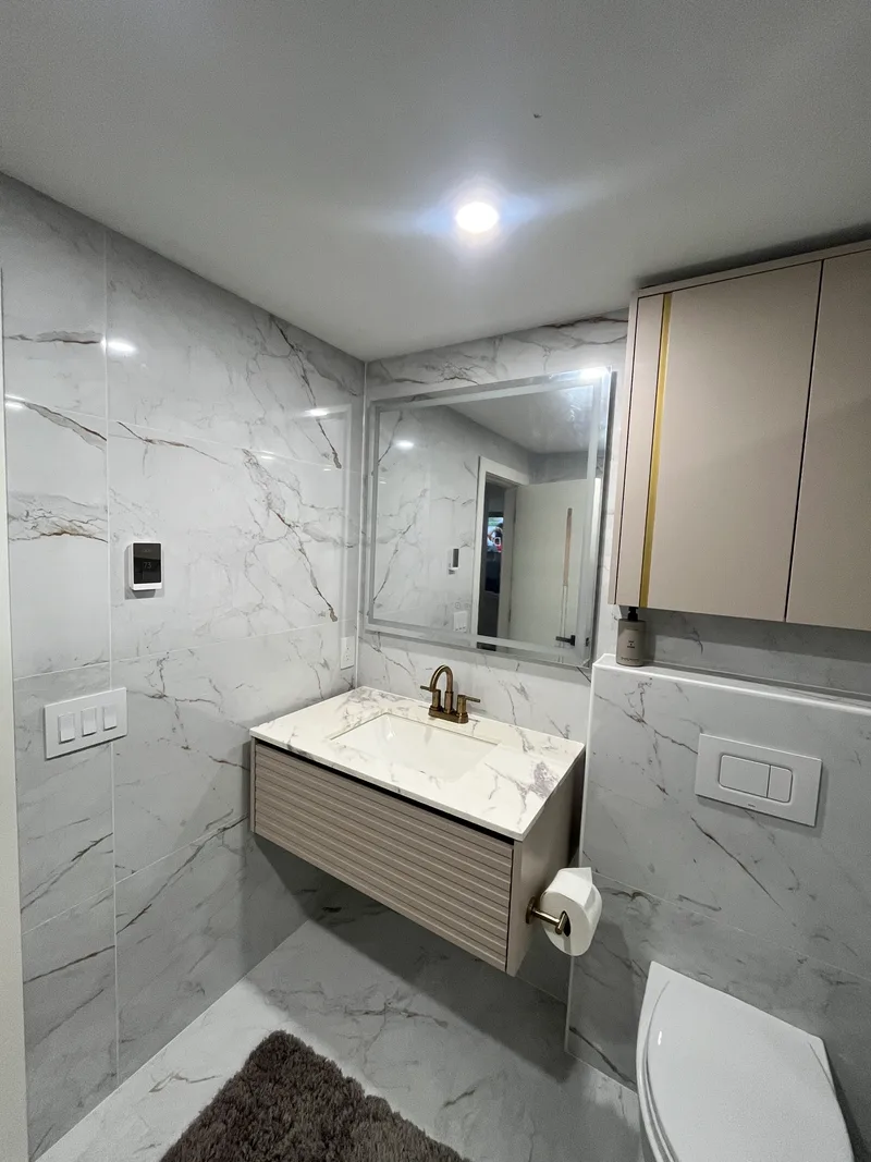 Finished Natick bathroom: wall-hung vanity, mirror and tiled walls after the full remodel